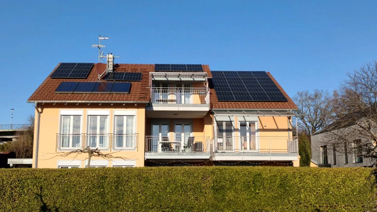 Außenansicht von Haus Sonnenseite in Wasserburg am Bodensee mit Südbalkonen, Garten und Photovoltaikanlage
