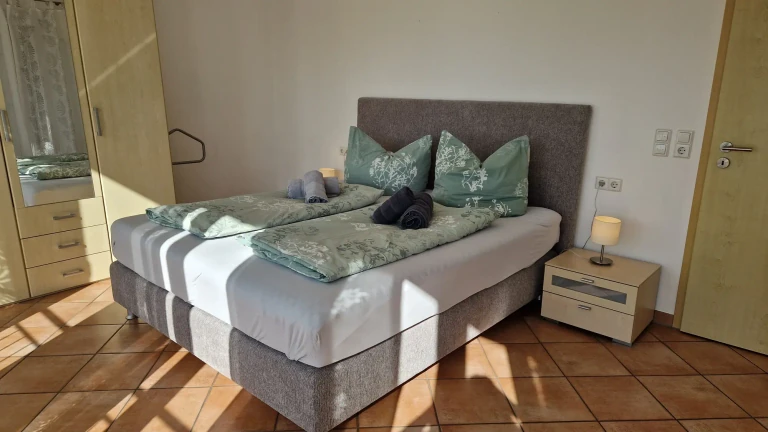 Gemütliches Schlafzimmer im Haus Sonnenseite mit Doppelbett und warmem Licht
